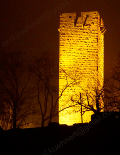 Nachtliches Anstrahlen des Vierkantturmes der Ravensburg zwischen Mühlbach und Sulzfeld betont die Natursteinfassade.
